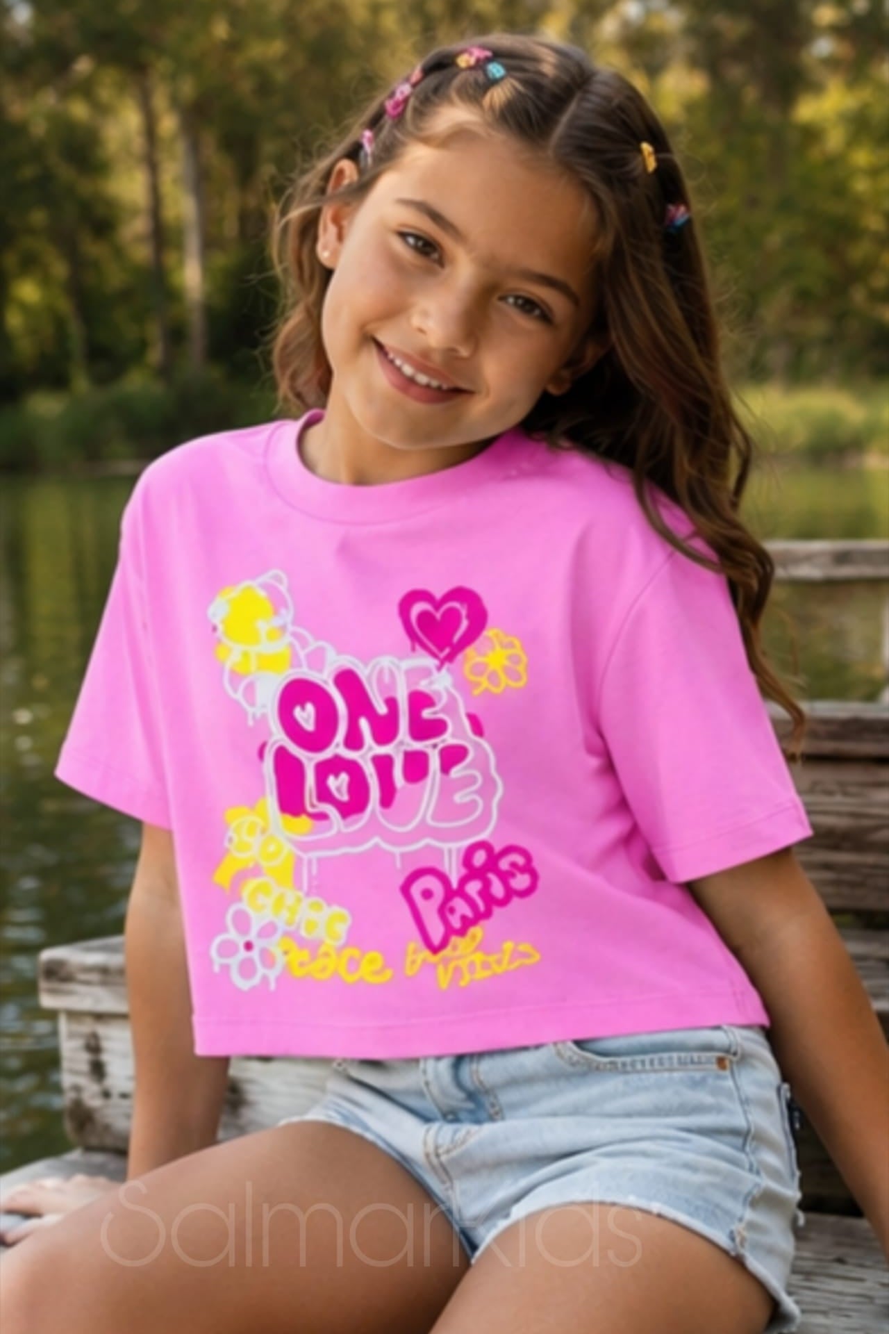 Uma t-shirt cheia de energia e estilo para as meninas que adoram se destacar! Com estampado colorido "One Love" em tons vibrantes de rosa, amarelo e branco, esta t-shirt é perfeita para os dias quentes de verão.

✨ Disponível em: Verde, Rosa e Preto 🌸 Estampado: One Love / Paris / Peace & Vibes 👕 Corte: Cropped descontraído 🌿 Material: 100% algodão (fresco e confortável)

Ideal para combinar com calções, calças de ganga ou saia — o look perfeito para a miúda cheia de personalidade!